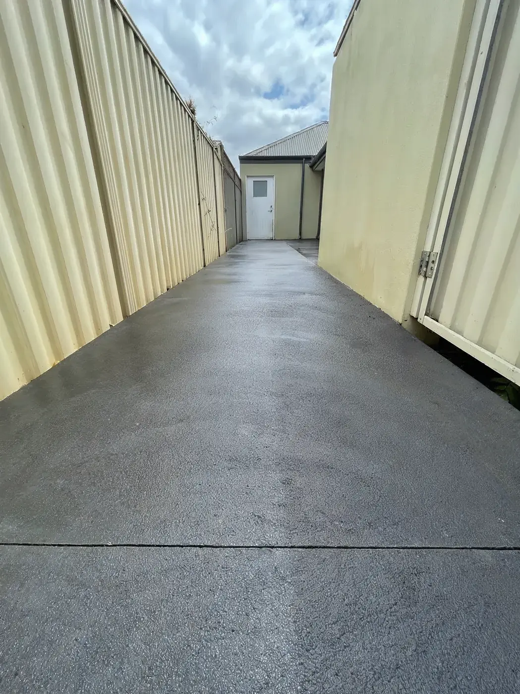 Narrow side-access concrete path poured between a fence and a garage wall, Perth