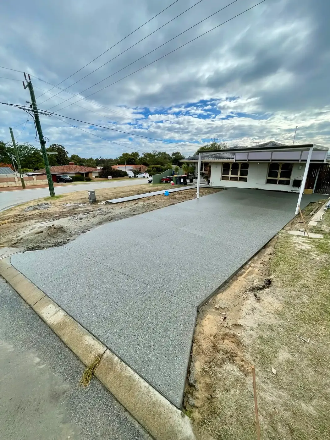 Fresh concrete driveway poured across a corner block, Perth