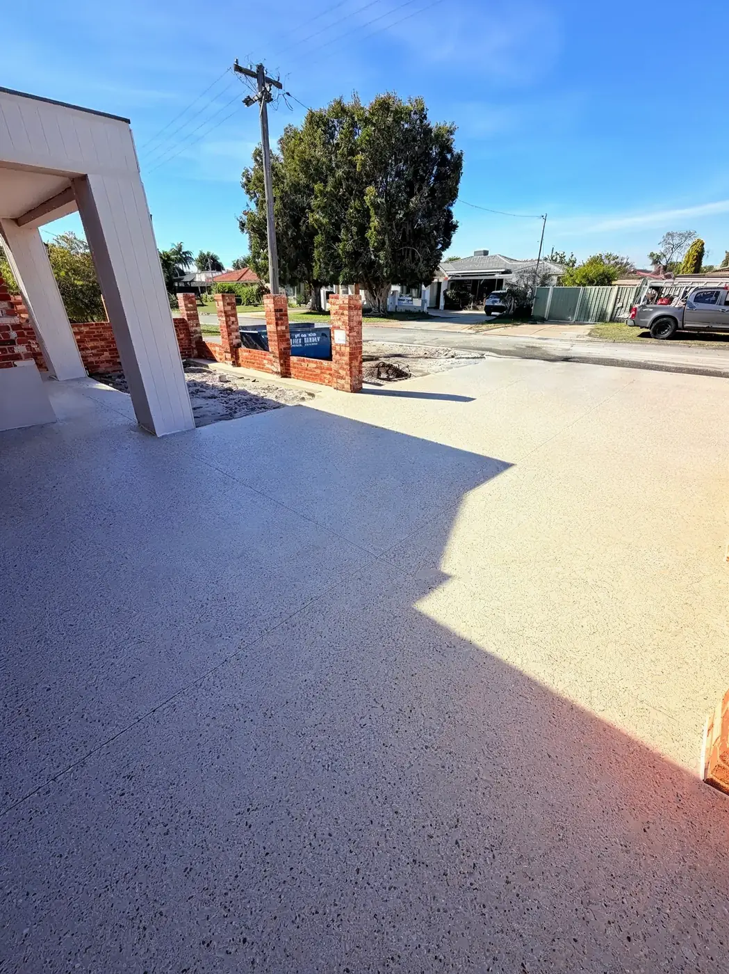 Pale honed concrete frontage beside brick pillars on an established Perth street
