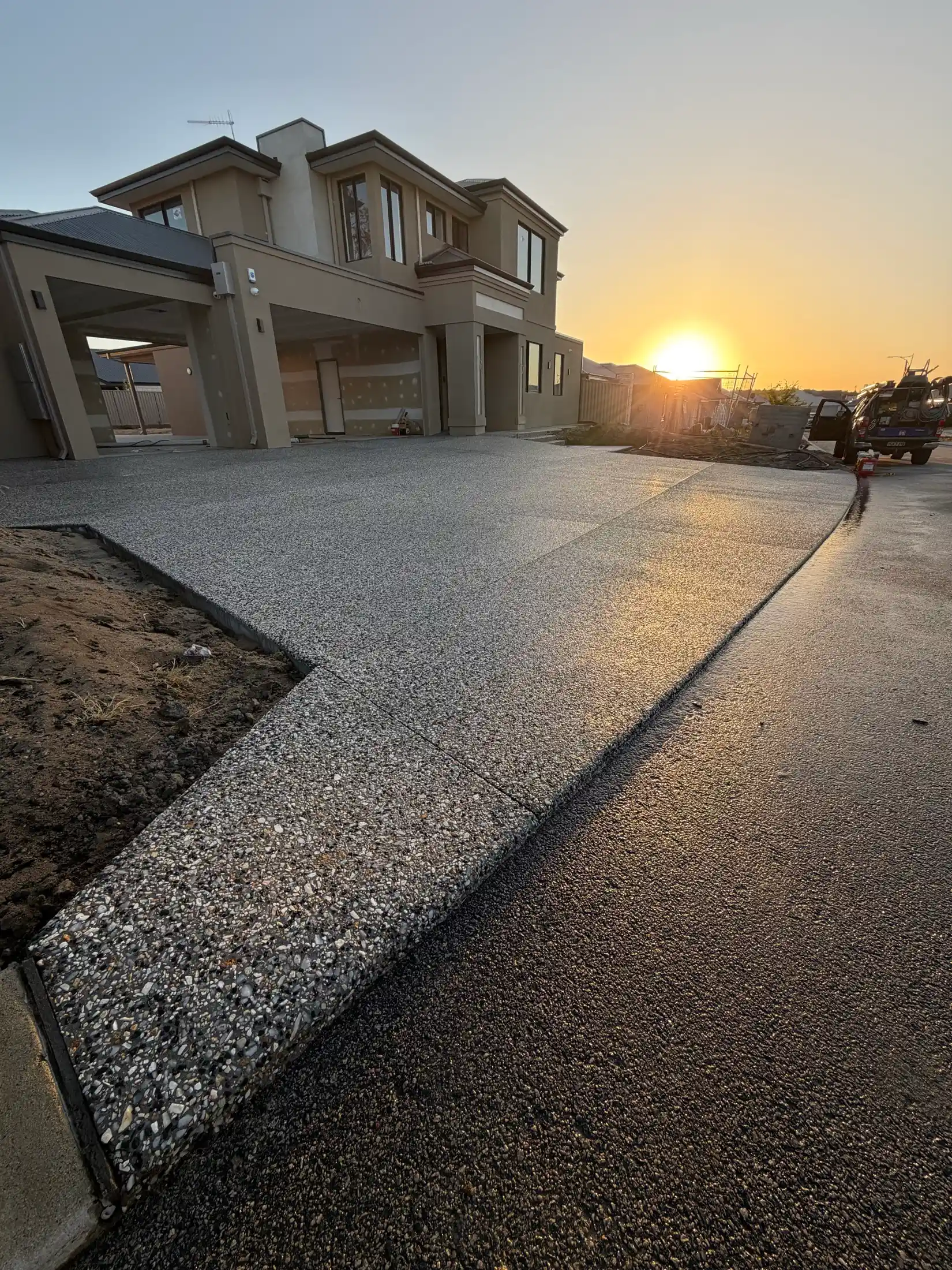 Exposed aggregate driveway glowing at sunset outside a new Perth home