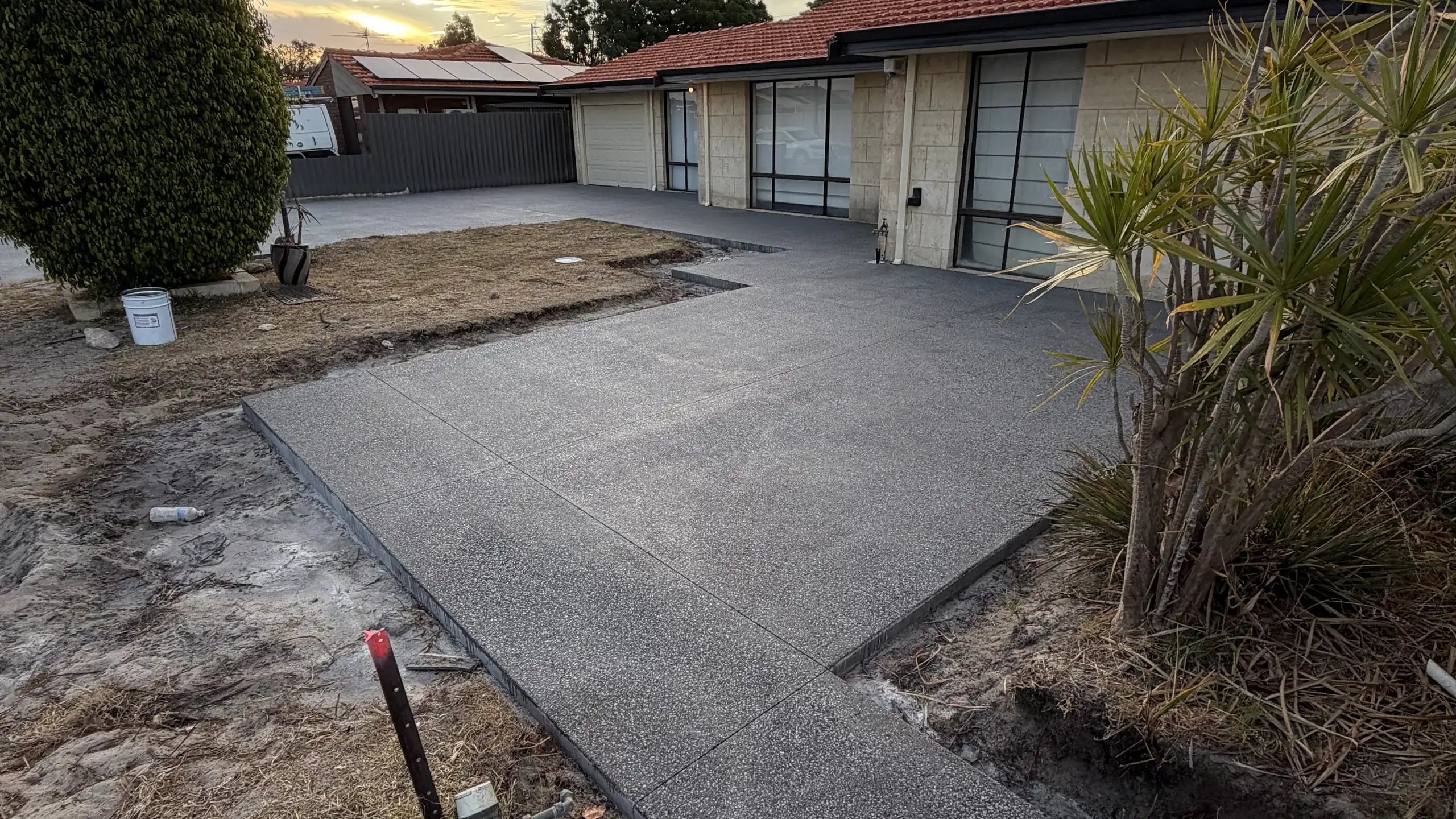 New exposed aggregate driveway at dusk on an established Perth block