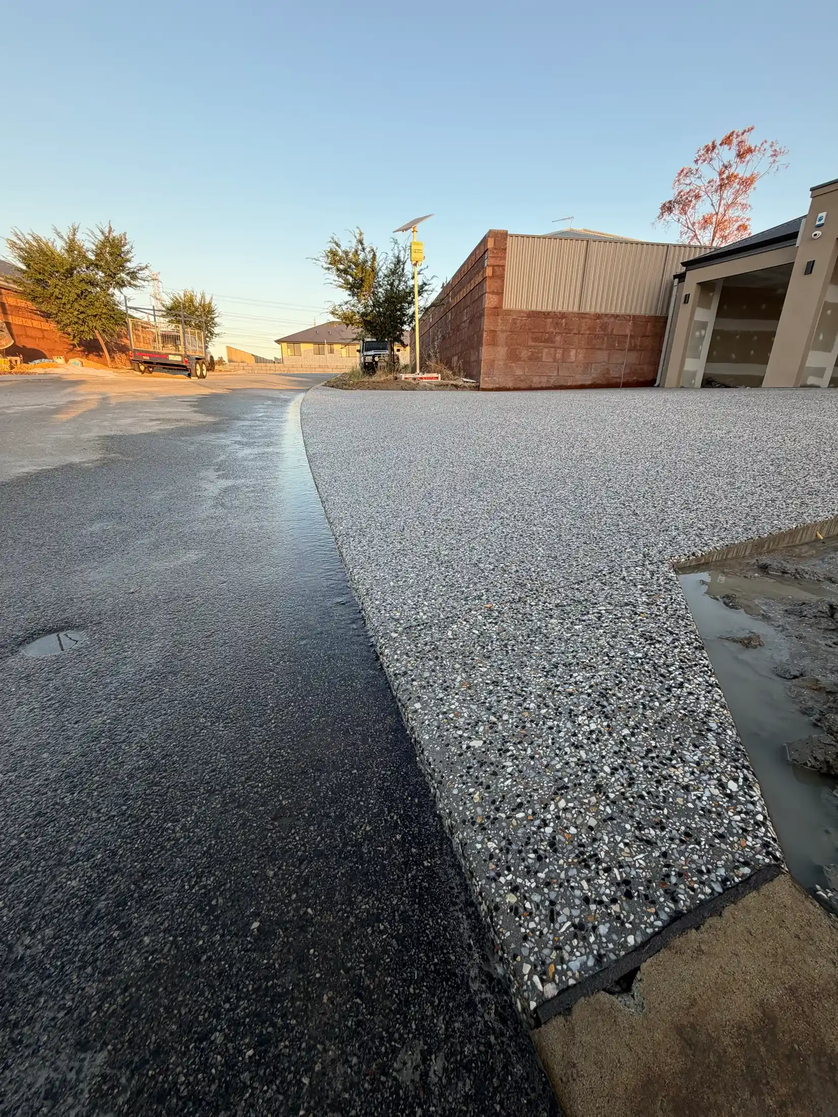 Fresh exposed aggregate concrete driveway at dusk on a Perth home by Only Concrete