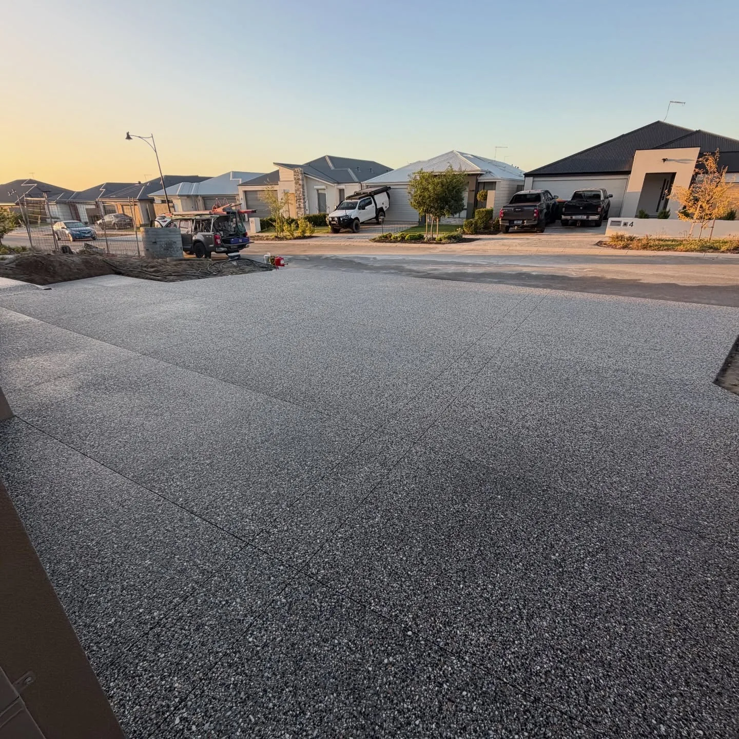 Wide exposed aggregate concrete driveway at sunset on a Perth home by Only Concrete